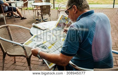 Stuttgart Germany - Aug 15 2018: Rear View Of Senior Man Reading Die Bild Newspaper Featuring Articl