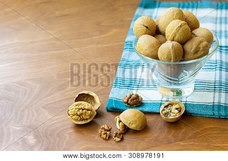Whole Walnuts And Walnut Kernel Halves Without Shell On A Dark Wooden Table And Checkered Towel, Clo