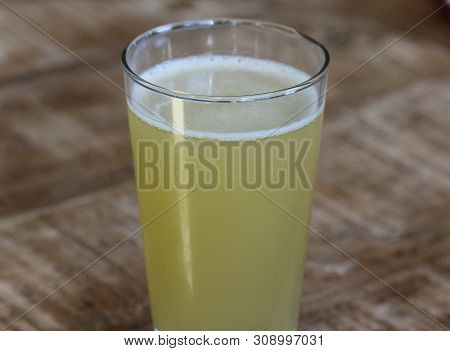 Close Up Of Glass Filled With Radler, Mixture Of Beer And Sparkling Lemonade, On Wooden Background