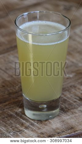 Close Up Of Glass Filled With Radler, Mixture Of Beer And Sparkling Lemonade, On Wooden Background