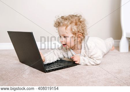 Cute Blonde Curly Toddler Baby Boy Working On Laptop. Little Kid Child Using Technology. Early Age E