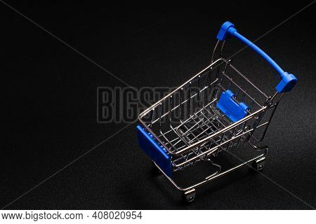 Small Blue Shopping Cart On A Black Background. Copspace