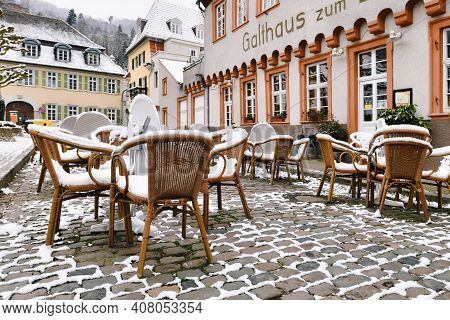 Heidelberg, Germany - February 2020: Empty Tables With Chairs Covered In Snow In Front Of Outdoor Re