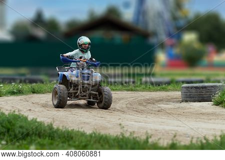 A Child Rides An Atv On The Track