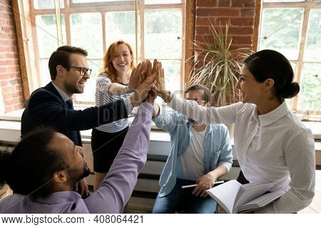 Excited Multiethnic Colleagues Engaged In Teambuilding Activity At Meeting