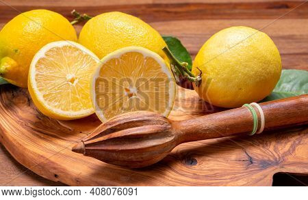 Fresh Ripe Yellow Italian Lemons And Wooden Juice Squeezer, New Harvest