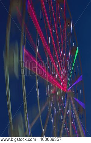 Carnival Ride Showing A Spinning Ferris Wheel In Action- Long Exposure Shot.