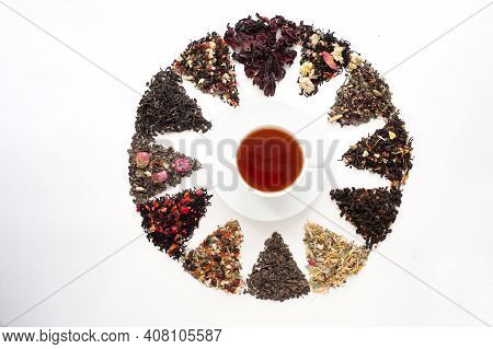 Different Types Of Tea And Herbal Mixtures With Berries Laid Out In A Circle Around A White Cup Of T