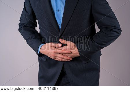 Office Worker With Abdominal Pain, Stomach Ache On Gray Background