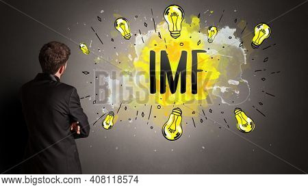 businessman drawing colorful light bulb with IMF abbreviation, new technology idea concept