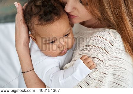 Loving Young Caucasian Mother Hugging Cute Infant African American Baby Daughter Expressing Single P