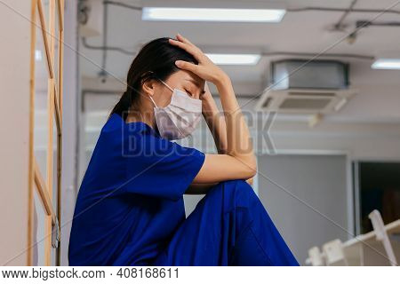 Young Asian Woman Nurse Wearing Uniform And Surgical Mask Looking Distraught And Sad Sitting On The 