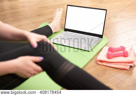 Online Yoga Fitness. Woman Holding Knee On Leg. Warm-up Before Doing Online Yoga Fitness. Mockup Lap