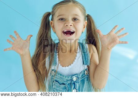 Portrait Of Preschooler Girl With Open Mouth Without Milk Tooth. High Quality Photo