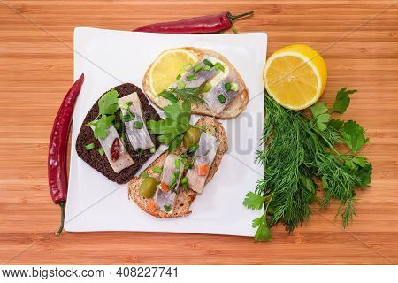 Different Open Sandwiches Made With Slices Of Pickled Atlantic Herring Fillet And Various  Bread Kin