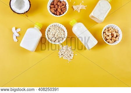 Alternative Types Of Vegan Milks In Bottles On A Yellow Background