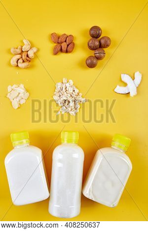 Alternative Types Of Vegan Milks In Bottles On A Yellow Background