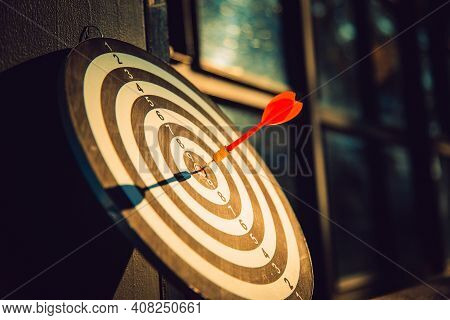 Dart Arrow Hit On Bulleyes Of Dartboard To Represent That The Business Reached The Target  With Dark