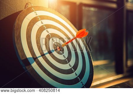 Dart Arrow Hit On Bulleyes Of Dartboard To Represent That The Business Reached The Target  With Dark