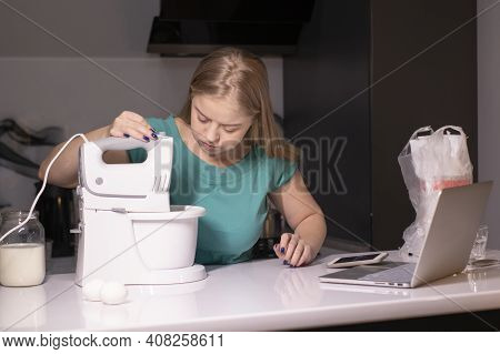 A Blonde Woman Chef Videoblogger Cooking In The Kitchen And Filming, Online Learning Or Remote Cooki