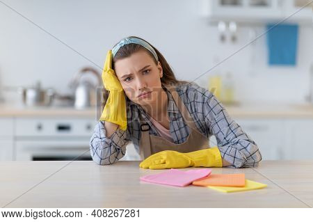 Unhappy Young Woman Tuired From Housework At Kitchen, Needing Break From Domestic Duties. Overworked