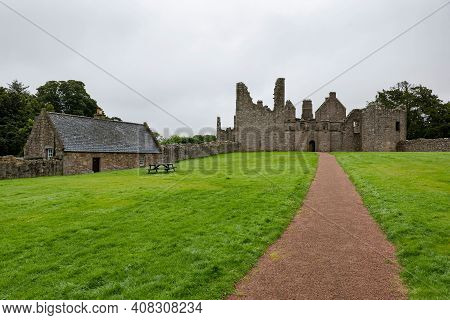 The Pathway And Green Lawn Of Tolquhon Castle In Tarves, Ellon, Scotland, Uk In Overcast Weather
