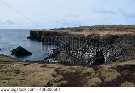 Amazing Black Rock Cliffs With Basalt Columns On The Coastline.