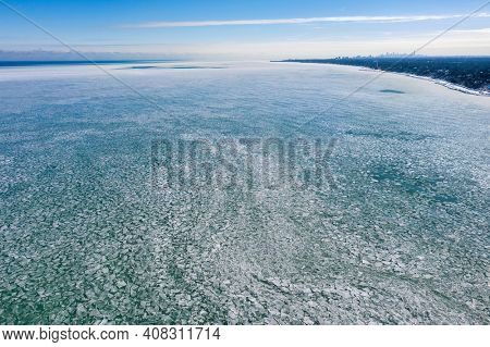 Aerial view of an icy Lake Michigan with Chicago's skyline seen in the distance after an intense cold spell.