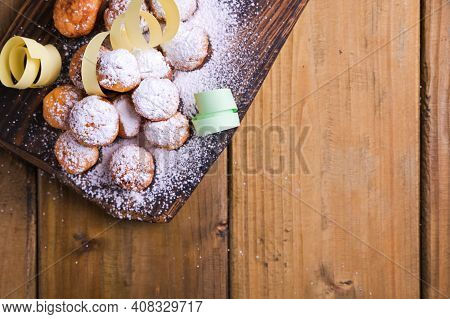 Baked Castagnole With Powdered Sugar And Confetti On A Wooden Table. Street Food, Round Biscuits Wit
