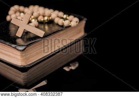 Closeup Of Wooden Christian Cross On Bible And Prayer Beads On Black.church Utensils.
