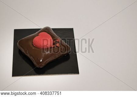 One Black Take Away Cardboard Filled With Sweet Chocolate Pastry With Red Heart Shape In The Middle.