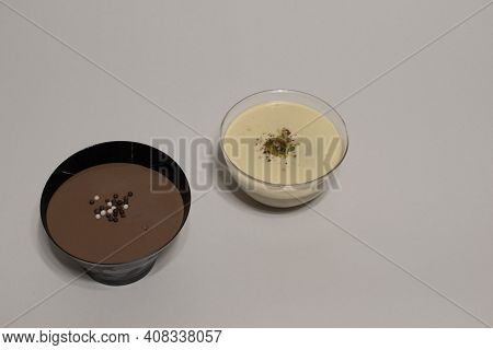 Close Up View Of Two Fresh Black And White Chocolate Pastry Cakes In Plastic Cake Cup With Crunch Ch