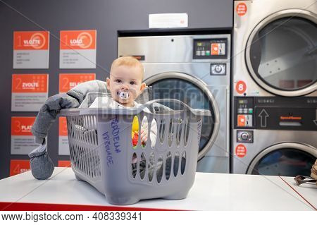 Prague, Czech Republic - 16.12.2020: Baby Girl In The Plastic Basket Waiting In Laundry Room With Sp