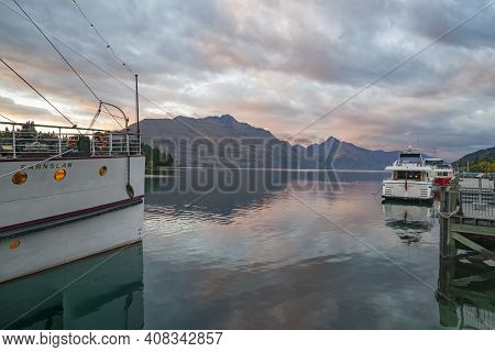 Queenstown New Zealand - March 1 2015; Tourist Boat Tss Earnslaw And Luxury Launch Parked At Pier In