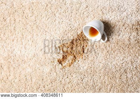 Overturned Cup And Spilled Tea On Beige Carpet, Top View. Space For Text