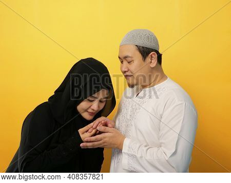 Happy Asian Muslim Couple Doing Greeting Gesture, Apologize And Forgiving Each Other On Eid Mubarak 