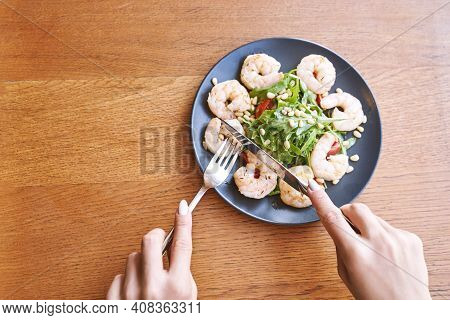 Young Woman At Restaurant Eating Shrimp Salad. Health Food Concept. Fork And Knife. Ountdoor Cafe. H