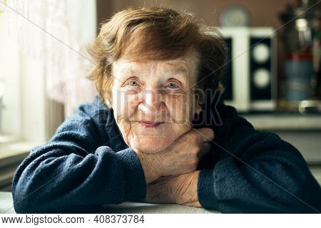 Portrait of an happy old woman in her home.