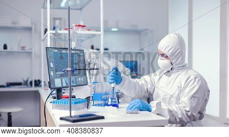 Medic Wearing Ppe Suit In Global Outbreak Working With Micropipette In Glass Flask. Chemist In Moder
