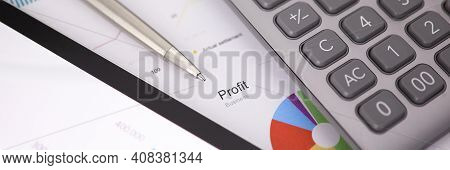 Siver Pen Calculator And Tablet Pc Lie On Office Table Against Business Chart Closeup Background.