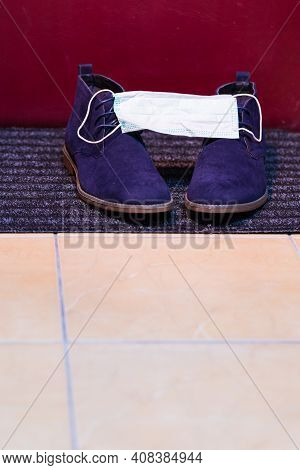 Pair Of Mens Blue Suede Semi-brogue Boots Covered With Facial Medical Mask As  Protection Symbol.
