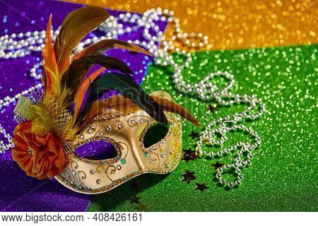 Festive, Colorful Mardi Gras Or Carnivale Mask And Beads On Golden, Green And Purple Background. Ven