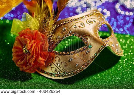 Festive, Colorful Mardi Gras Or Carnivale Mask And Beads On Golden, Green And Purple Background, Clo