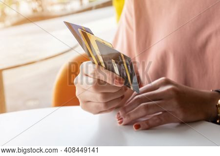 Cropped Shot View Of Female Hands Holding Her Credit Cards. Credit Card Lets Cardholders Borrow Fund