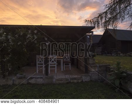 View Of Summer Garden With Tiber Wooden Gazebo Pergola With Blooming Climbing Plant Flowers And Whit