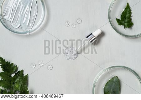 Cosmetic Pipette And Drop Of Cosmetic Product On Pastel Green Background With Eucalyptus Leaves. Nat