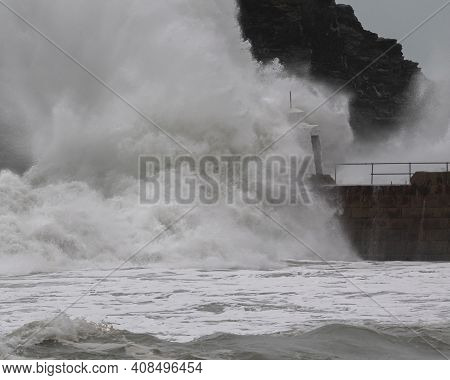 Side On View Of Wave Hitting Man Made Structure, Monkey Hut In Portreath Cornwall