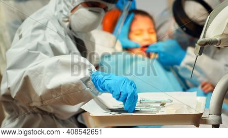 Medical Team Working With Sterilized Tools Wearing Face Shield, Coverall Suit, Mask And Gloves Durin
