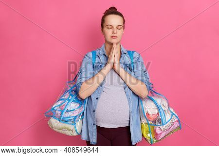 Beautiful Pregnant Woman With Hair Bun,expecting Baby, Keeps Palms Together And Prays, Posing Isolat