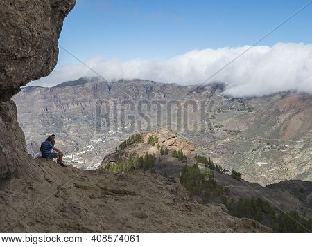 Cruz De Tejeda, Canary Islands, Spain December 15, 2020: Group Of Tourist Hikers Sitting At Feet Of 